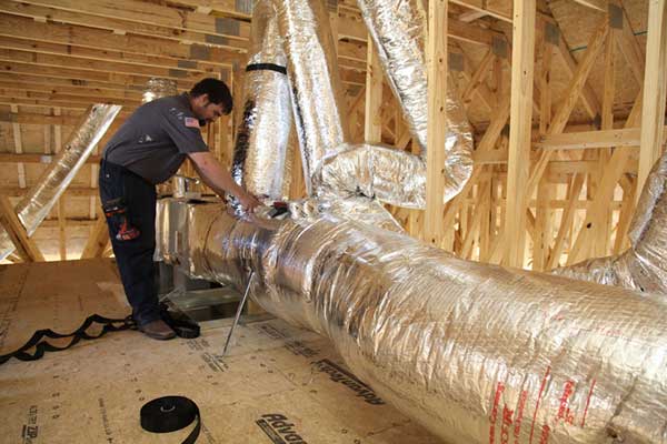 Airmax technician installing duct for heating