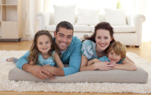 Happy Family On Carpet In Living Room