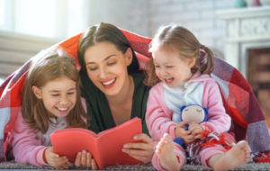 Mother Reading A Book To Her Daughters