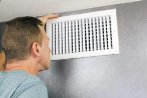 Man Looking Into Ac Vent