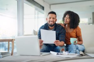 Couple Smiling And Looking At Paper