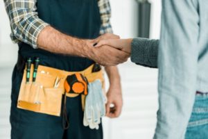 Handshake Between Contractor With Tool Belt And Client